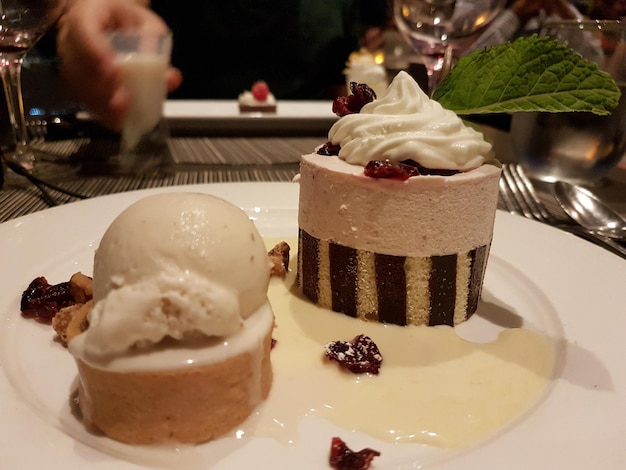 Primer plano de un pastel servido con helado en un plato