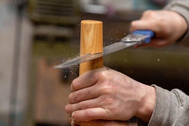 Primer plano de la pata de la mesa de corte de carpintero con sierra de mano