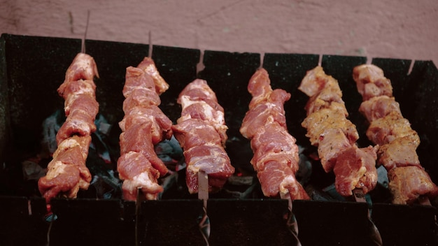 Primer plano patatas fritas brochetas de carne Barbacoa en brochetas Parrilla Ocio comida gente vacaciones Concepto un hombre cocina carne en una parrilla para sus amigos