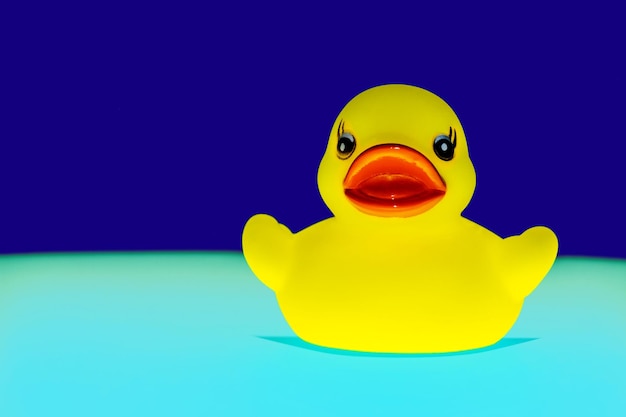 Foto primer plano de un pato de goma amarillo sobre un fondo azul