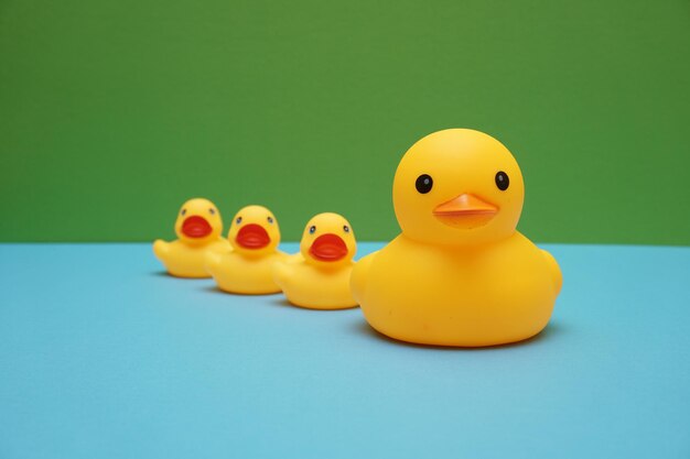 Foto primer plano de patos de goma en una mesa azul contra un fondo verde