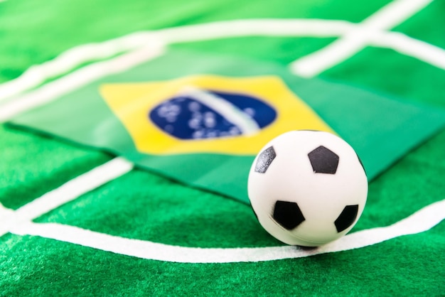 Foto primer plano de una pequeña pelota de fútbol con bandera en textil verde