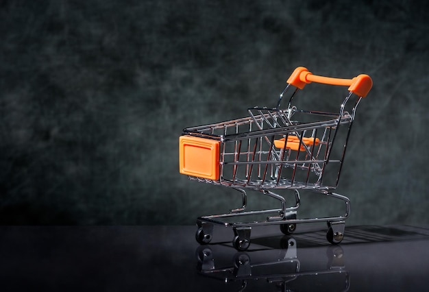 Primer plano de un pequeño carrito de compras contra la pared