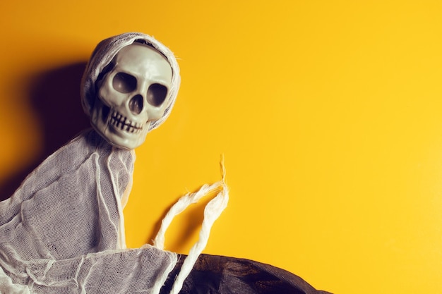 Foto primer plano de un pequeño esqueleto humano sobre un fondo amarillo