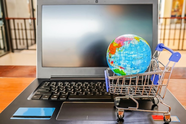 Foto primer plano de un pequeño globo en el carrito de compras en una computadora portátil