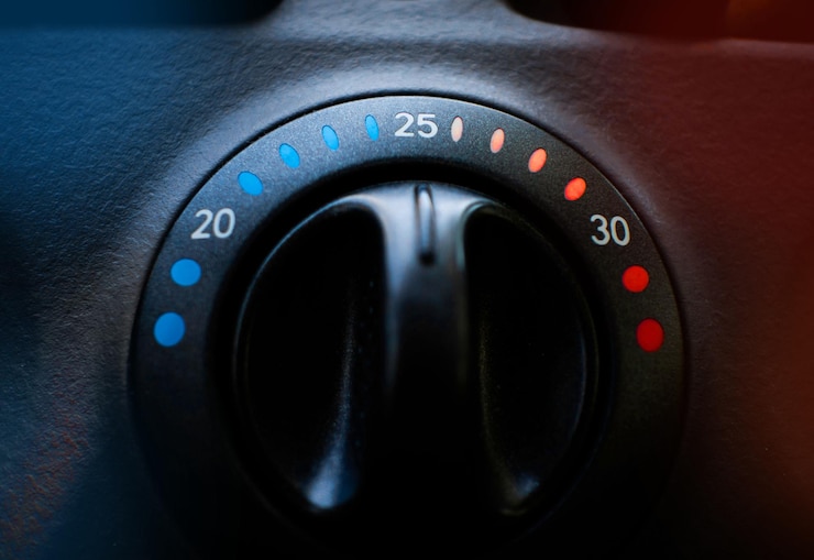 Foto primer plano de una perilla de control de clima de automóviles con colores cálidos y fríos en los lados