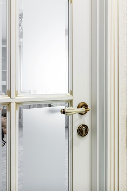 Primer plano de la perilla o manija de la puerta con estilo y elegante en la puerta blanca Manija de la puerta blanca y bronce vintage en la puerta que es adecuada para el interior de una casa refinada Concepto de detalles