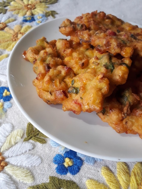 Primer plano de Perkedel Jagung o Bakwan Jagung buñuelos de maíz tradicionales indonesios servidos en un plato blanco