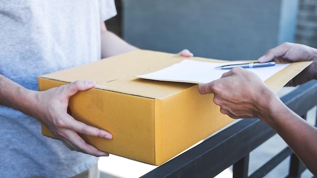 Primer plano de la persona de la entrega pidiendo al hombre que firme el documento