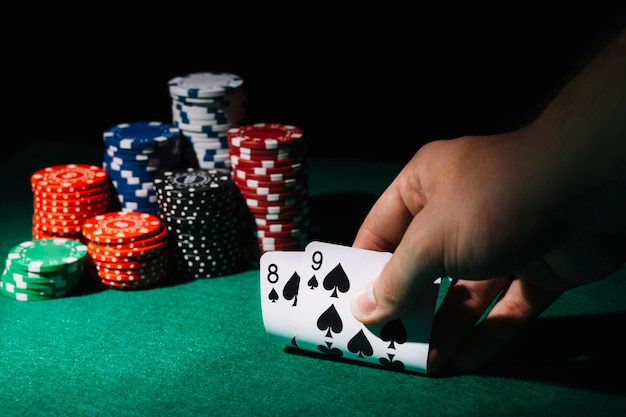 Foto primer plano de una persona jugando a las cartas en la mesa de casino