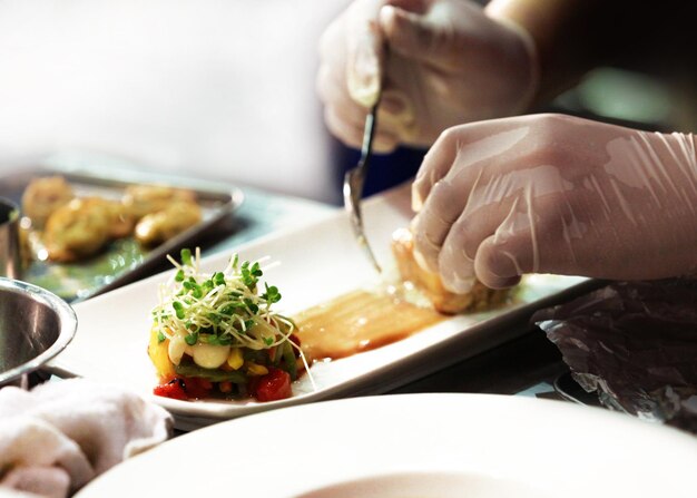 Foto primer plano de una persona preparando comida en un plato