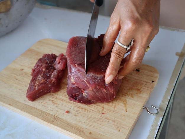 Foto primer plano de una persona preparando comida en la tabla de cortar