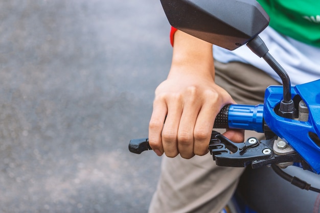 Primer plano de la persona que sostiene el manillar de la motocicleta