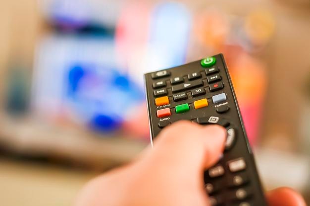 Primer plano de la persona que tiene el control remoto