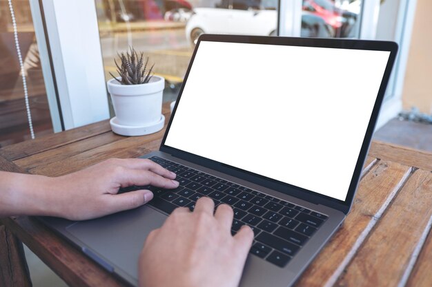 Primer plano de una persona que usa una computadora portátil en la mesa