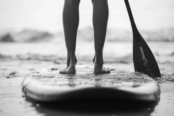 Un primer plano de una persona remando en una tabla en el agua capturando la esencia de la aventura al aire libre y el fitness