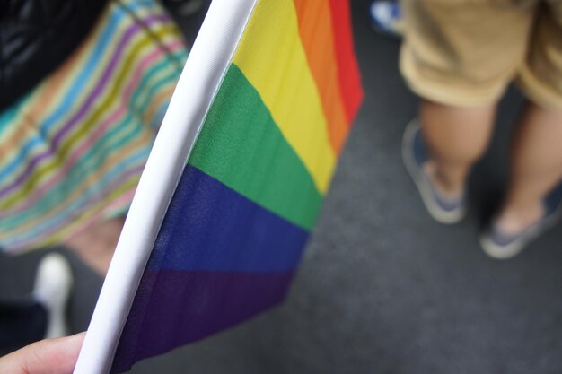 Foto primer plano de una persona sosteniendo una bandera arco iris