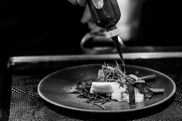 Primer plano de una persona sosteniendo comida en un plato sobre la mesa