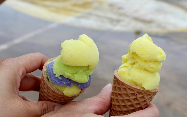 Foto primer plano de una persona sosteniendo conos de helado