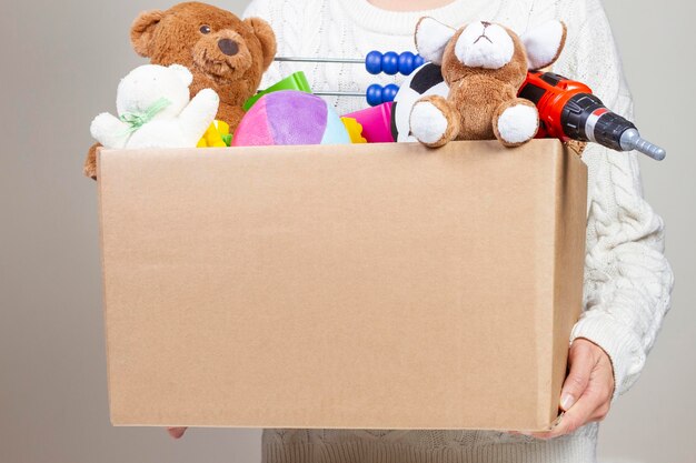 Foto primer plano de una persona sosteniendo juguetes de peluche en una caja