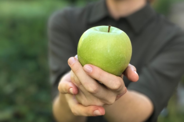 Primer plano de una persona sosteniendo una manzana