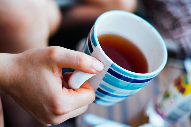 Primer plano de una persona sosteniendo una taza de té