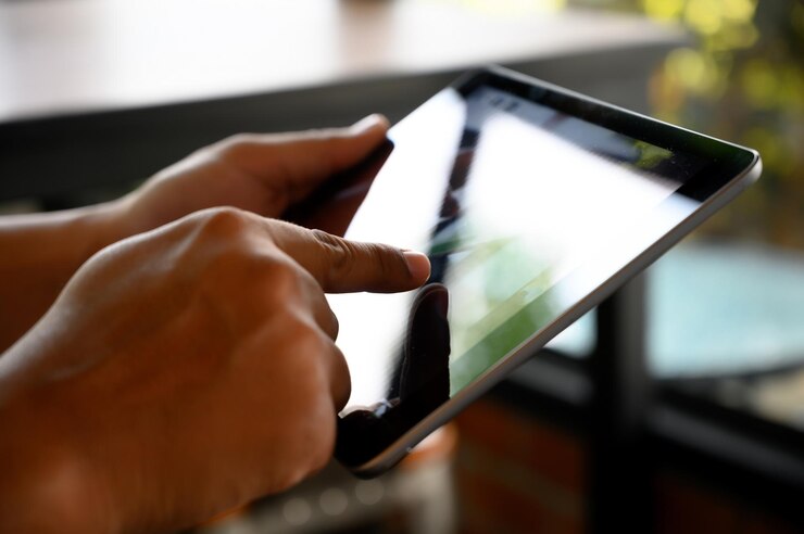 Foto primer plano de una persona con una tableta digital en la mesa en un restaurante