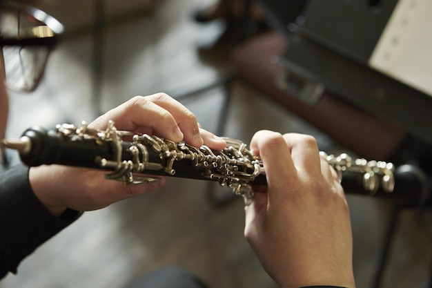 Primer plano de una persona tocando el oboe, en el interior