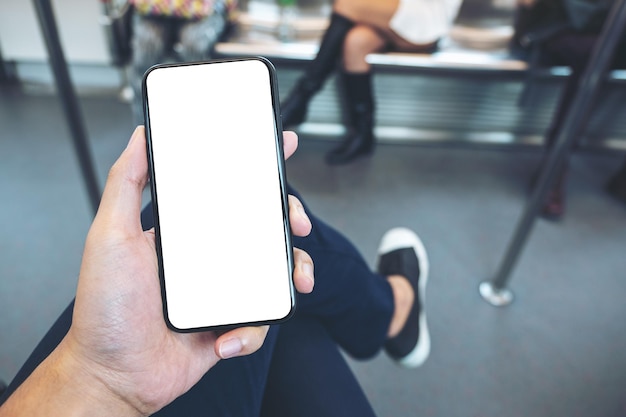 Primer plano de una persona usando un teléfono móvil en el tren