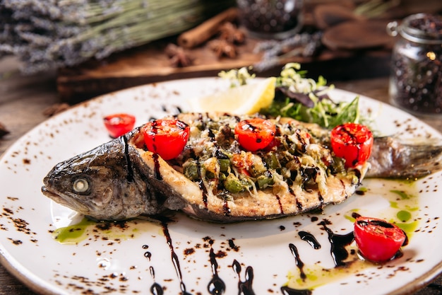 Primer plano de pescado relleno a la parrilla sobre la mesa de madera