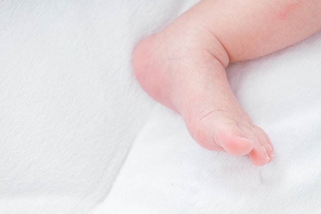 Primer plano del pie del bebé en la cama