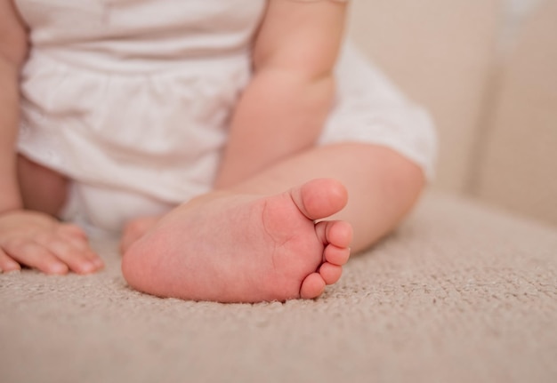 Primer plano del pie de un niño sobre un fondo beige con un lugar para el texto