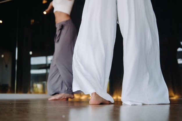 Foto primer plano de piernas de baile de mujeres en ropa deportiva haciendo yoga de baile en el gimnasio