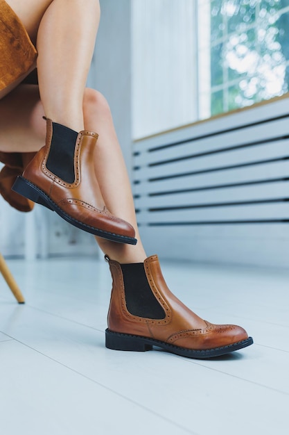 Primer plano de piernas femeninas con botas Chelsea de cuero marrón Nueva colección de otoño de zapatos de cuero para mujer 2022