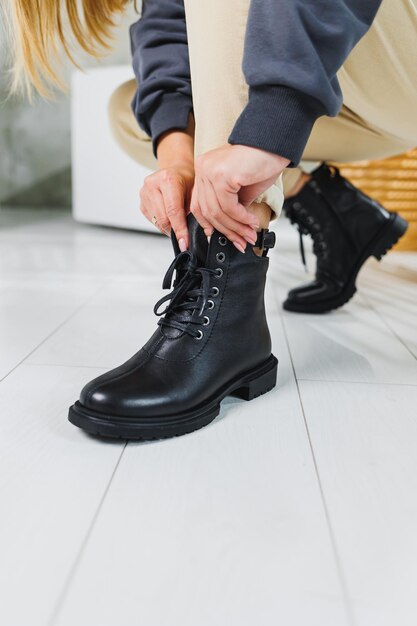 Primer plano de piernas femeninas en botas con cordones de cuero negro Zapatos de invierno para mujer Nueva colección de otoño de zapatos de cuero para mujer