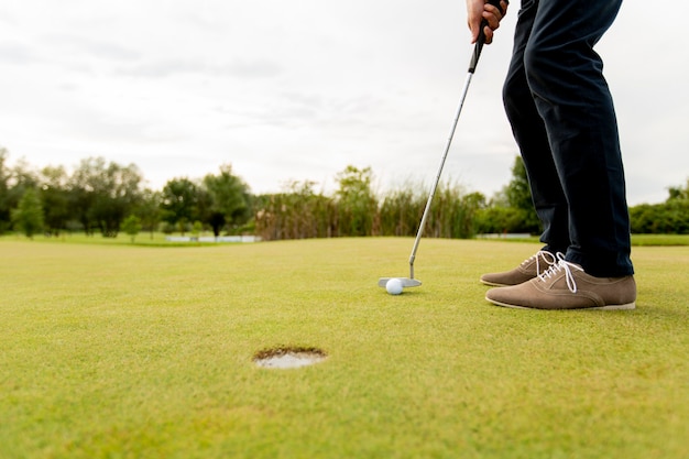 Primer plano de las piernas del joven jugando al golf