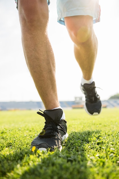 Primer plano de las piernas masculinas en zapatillas de deporte.