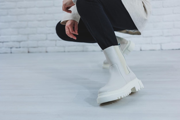 Primer plano de las piernas de las mujeres en botas blancas de otoño Botas de mujer hechas de cuero genuino
