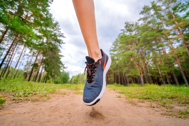 Primer plano de pies femeninos corriendo en el parque