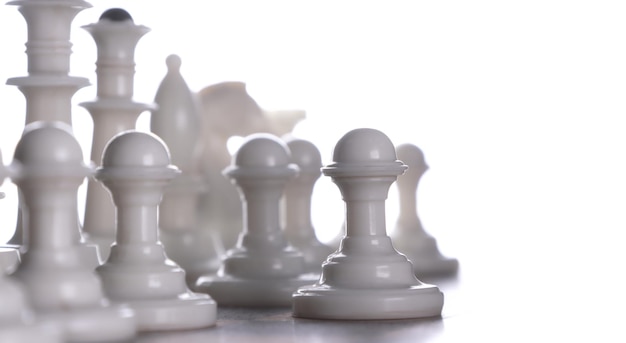 Foto primer plano piezas de ajedrez blancas en un tablero de ajedres fondo claro