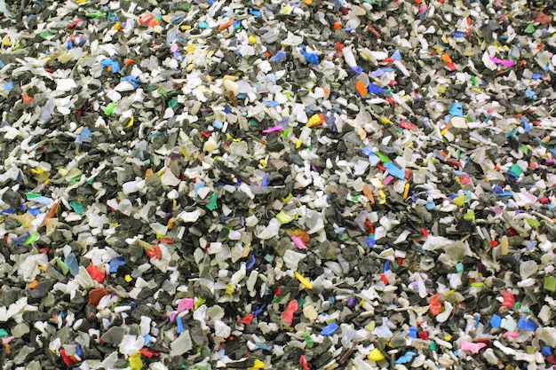 Primer plano de piezas de plástico trituradas preparadas para el reciclaje Material crudo de cables para la reproducción Sor