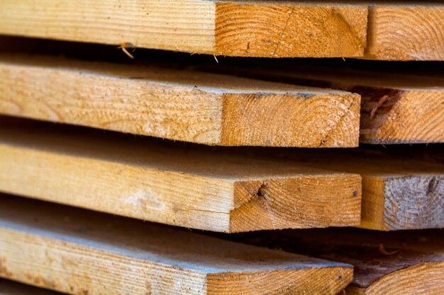 Primer plano de la pila cuidadosamente apilada de tableros de madera rugosa marrón natural