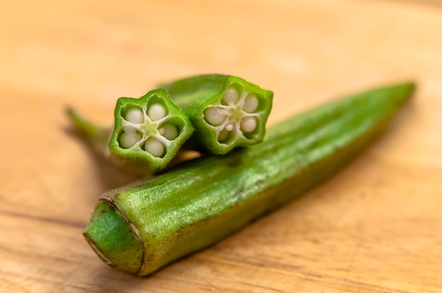 Primer plano de la pila de orgánicos okra en la madera. Okra frutas en la tabla de cortar