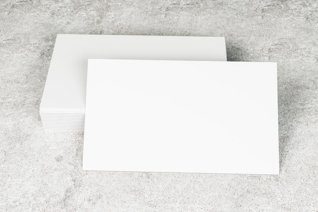 Foto primer plano de una pila de tarjetas de visita blancas y limpias en un escritorio de hormigón concepto de información y dirección simulacro de renderizado 3d