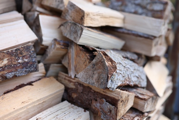 Primer plano de una pila de troncos de madera picada para la preparación de leña apilada para hogueras para el concepto de invierno