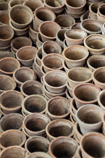 Primer plano de pilas de viejas macetas de terracota desgastada en el cobertizo de jardinería