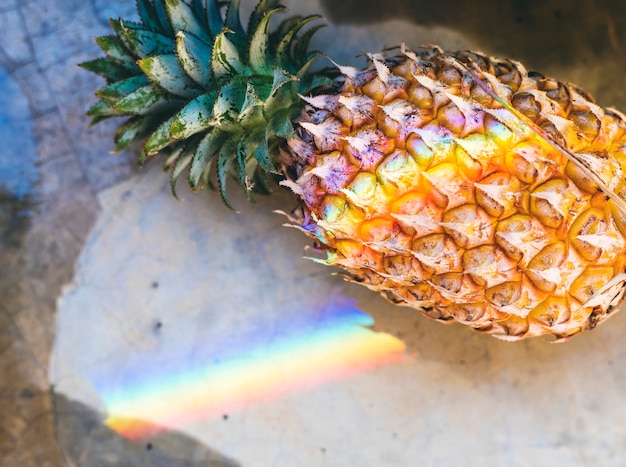 Primer plano de piña fresca con luz de prisma de arco iris