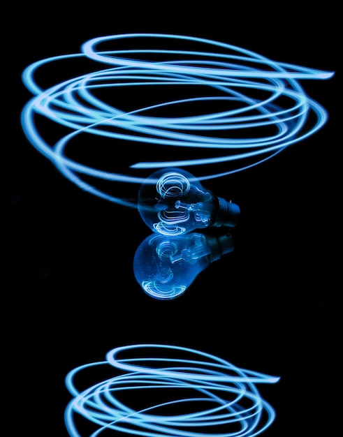 Primer plano de una pintura de luz sobre una bombilla sobre un fondo negro