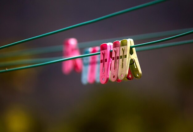 Foto primer plano de pinzas de ropa colgando en el cordón de la ropa