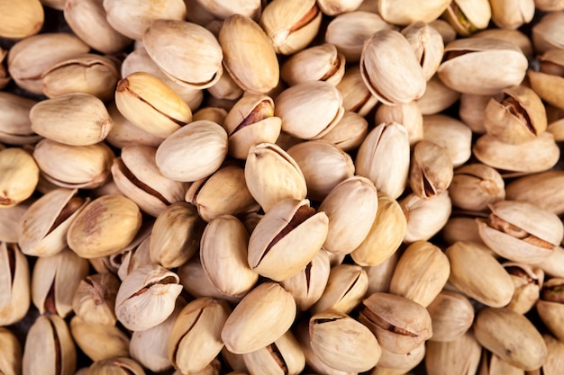 Primer plano de pistachos sobre fondo de madera en la foto de estudio. Bocadillos saludables y deliciosos